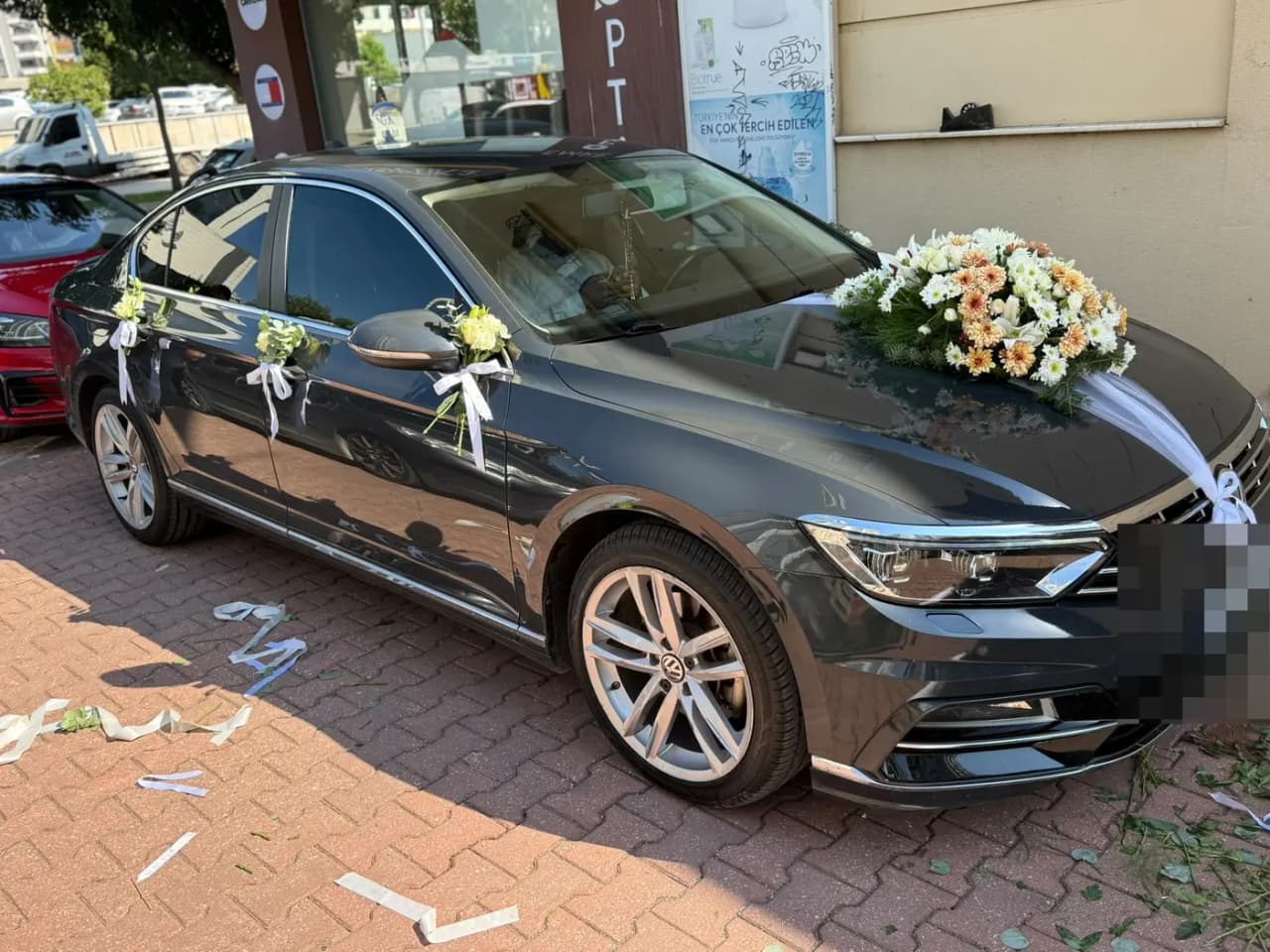 Koyu gri VW aracın ön kısmında beyaz tül fiyonklu süsleme