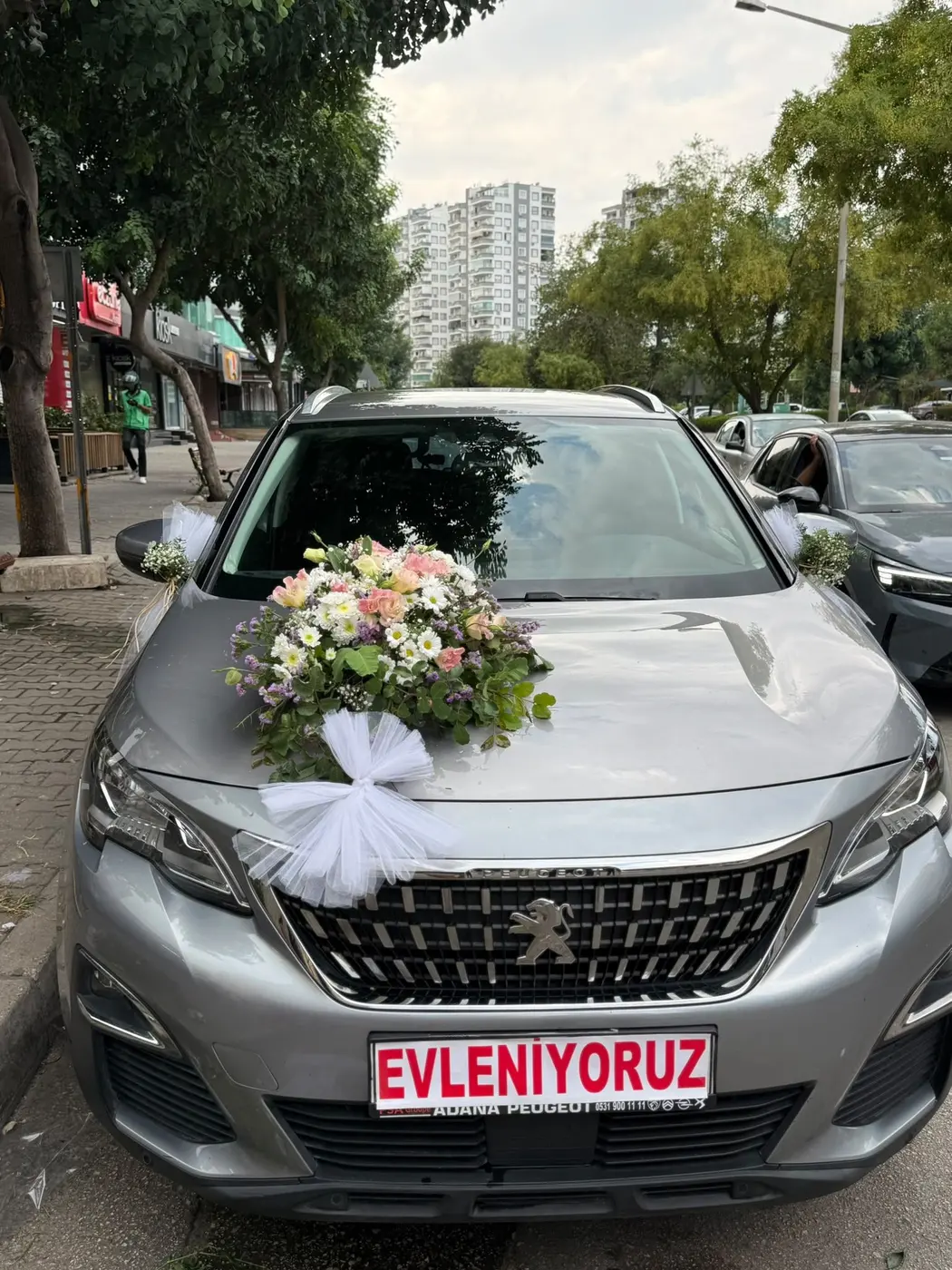 Gümüş Peugeot aracın kaputunda pembe ve beyaz çiçek buketi