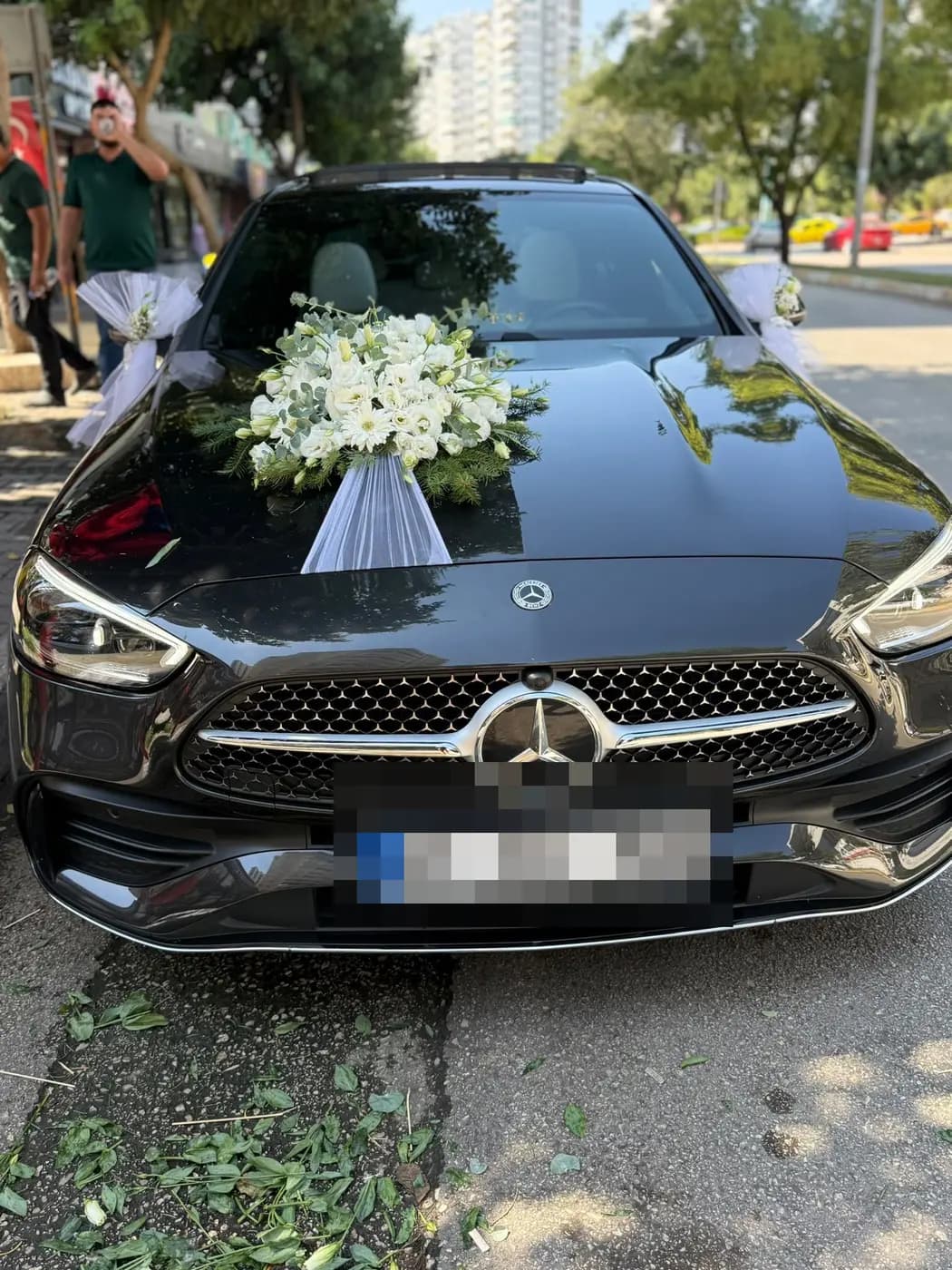 Siyah Mercedes aracın kaputunda beyaz çiçek buketi ve tül