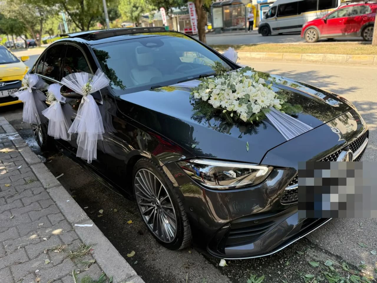 Siyah Mercedes aracın kapılarında beyaz tül fiyonklar ve kaput süslemesi