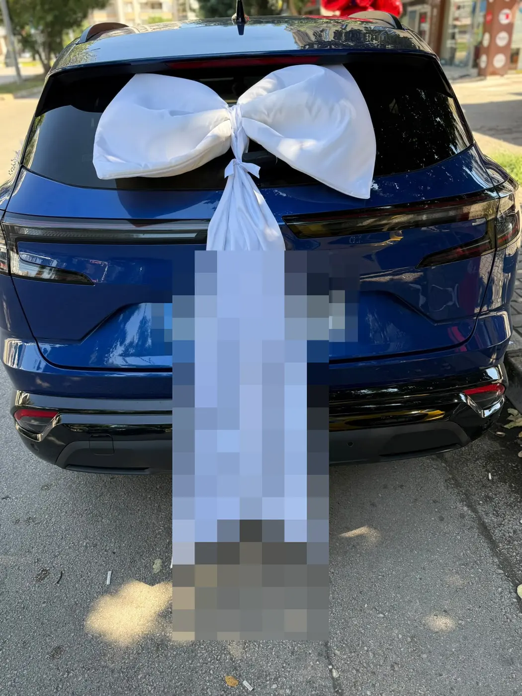 Mavi Renault aracın bagajında büyük beyaz saten fiyonk ve kurdele