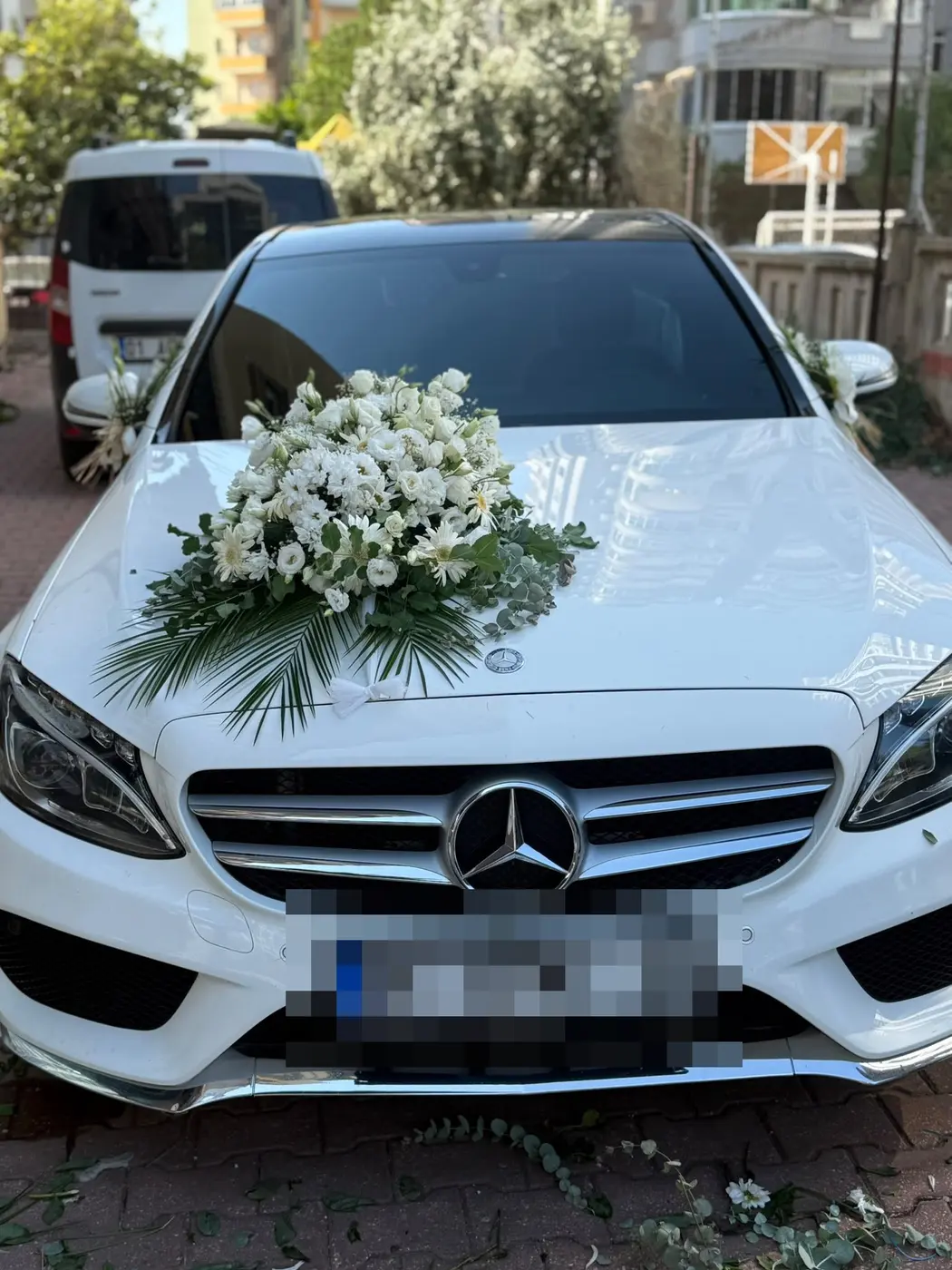 Beyaz Mercedes aracın kaputunda büyük beyaz çiçek buketi