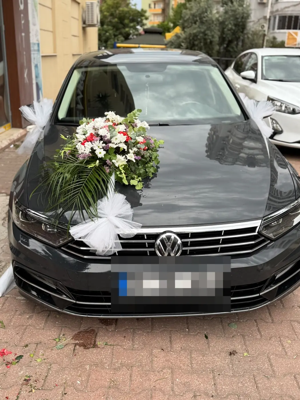 Siyah VW aracın kaputunda kırmızı ve beyaz çiçek buketi