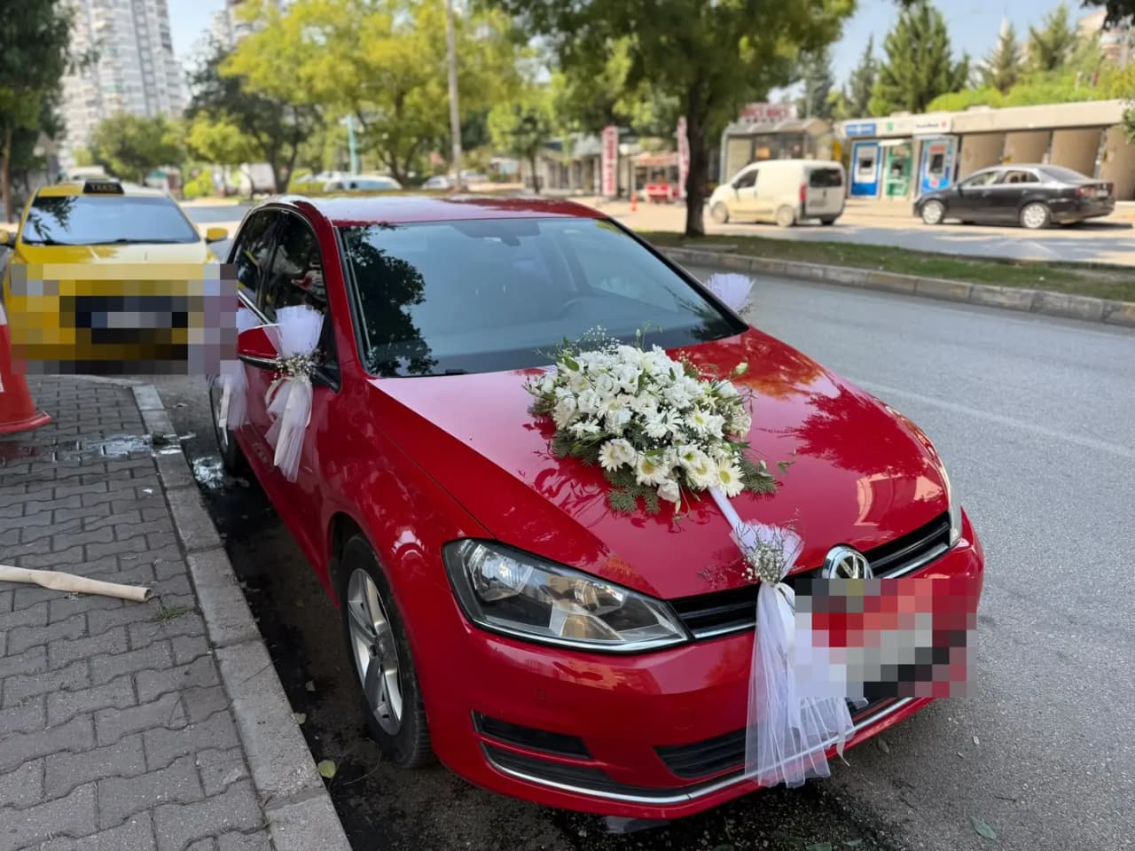 Kırmızı VW aracın kaputunda beyaz çiçek buketi ve tül fiyonklar
